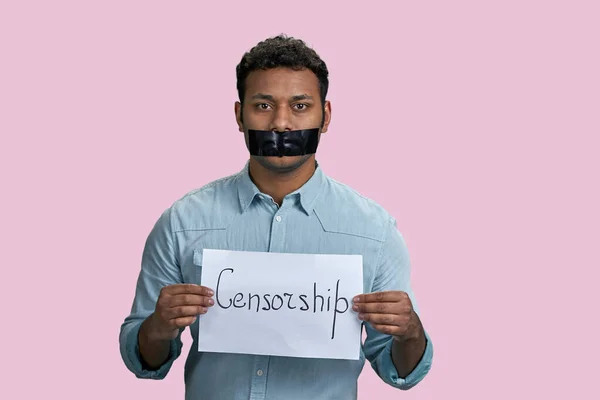 検閲の言葉で紙のシートを保持口テープで沈黙インドの男 ピンクの背景に隔離された — ストック写真