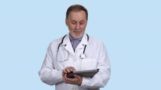 Sağlık Teknolojisini Kullanarak Dijital Tableti Elinde Tutan Yaşlı Bir Doktor — Stok video