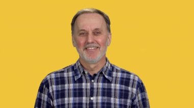 Gülümseyen Kafkasyalı yaşlı son sınıf öğrencisi. Turuncu üzerine izole edilmiş..