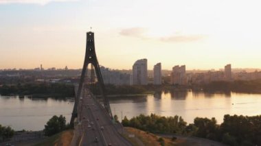 Nehir köprüsünün hava manzarası ve orta derecede trafik. Akşam gün batımı gökyüzü.