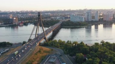 Nehrin üzerinde köprüsü olan bir şehir manzarası. Orta karar araba trafiği.