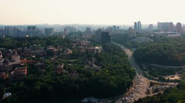 Yaz günü Kiev şehrinin insansız hava aracı manzarası. Otobanda trafik sıkışık. Bir sürü yeşil ağaç.