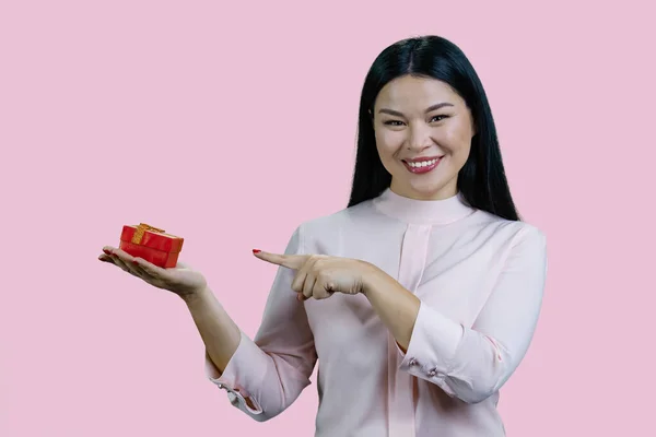 아시아인 여성의 초상화가 상자를 가리키고 있습니다 분홍빛 배경에 고립됨 — 스톡 사진