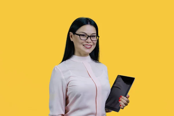 Portrait Smiling Asian Woman Glasses Holding Tablet Isolated Yellow Background — Stock Photo, Image