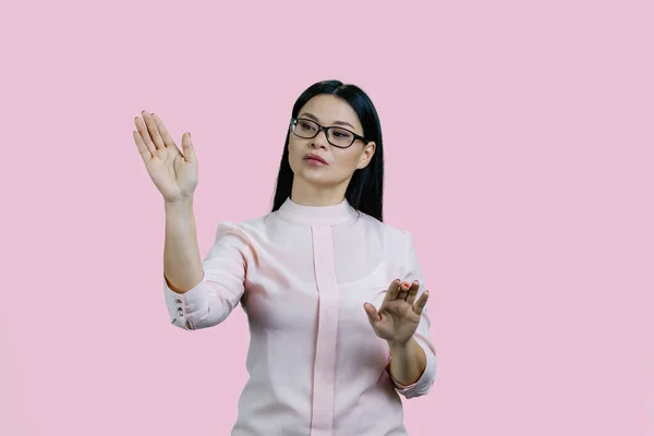 Young Asian Businesswoman Swiping Invsible Touch Screen Isolated Pink Background — Stock Photo, Image
