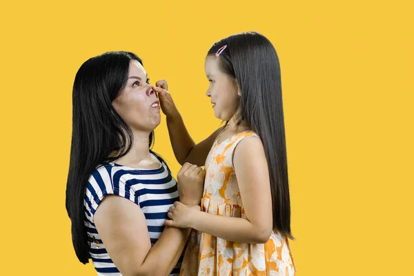 Niña Está Haciendo Una Nariz Cerdito Madre Aislado Sobre Amarillo — Foto de Stock