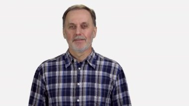 Gülümseyen kıdemli adam jest işareti gibi görünüyor. Yaşlı bir adam baş parmağını veriyor. Beyaz arkaplanda izole.