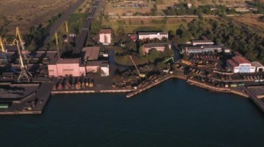 Kömür yığınlarıyla endüstriyel deniz limanının havadan görünüşü. Sevkiyat ve ulaşım kavramı.