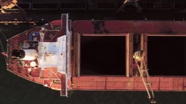 Dünyasal vinçler tanker gemisine kömür yüklüyor. Sevkiyat ve ulaşım kavramı.