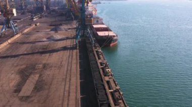 Bir deniz limanında yüklü tren ve tanker gemisi. Perspektif drone görünümü.