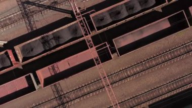 Boş kahverengi arabalarla kargo treni hareket ediyor. Havadan üst görünüm.