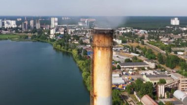 Duman emisyonlu eski paslı endüstriyel baca. Şehir nehir kirliliği kavramı.