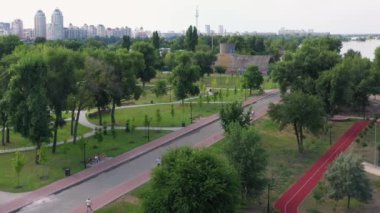İHA 'nın bakış açısından şehir parkının havadan görüntüsü. Yeşil ağaçlar ve kaldırımlar.