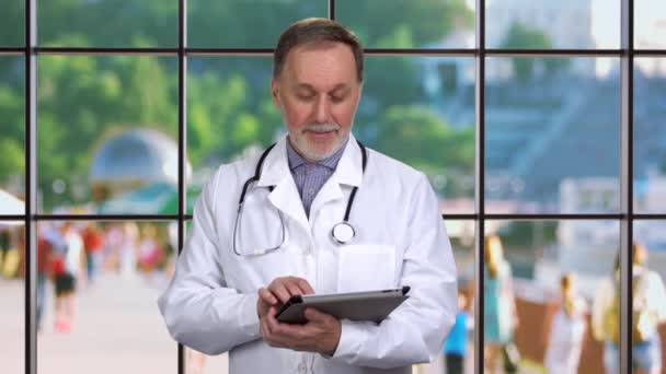 Starý Starší Lékař Drží Digitální Tablet Rukou Kostkované Okno Výhledem — Stock video