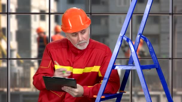 Trabajador Construcción Uniforme Rojo Naranja Hardhat Escribir Algo Usando Portapapeles — Vídeos de Stock