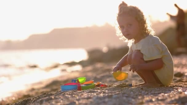 모래에 장난감과 귀여운 모래를 흔들며 — 비디오