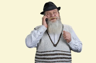 Telefonda konuşan pozitif sakallı yaşlı adamın portresi. Beyazda izole edilmiş.