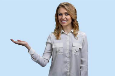 Gülümseyen ve fotokopi çeken mutlu sarışın kadın. Pastel mavi arkaplan.