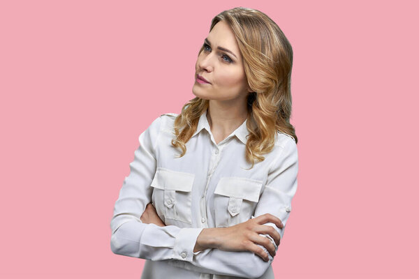 Young businesswoman in white shirt standing with folded arms. Isolated on pink background.