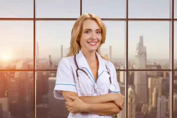 Kollarının Kavuşturulduğunu Duyan Mutlu Gülümseyen Kadın Doktor Arkaplanda Şehir Manzarası — Stok fotoğraf