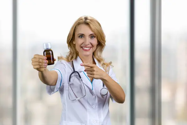 Mutlu Gülümseyen Kadın Doktor Ilaç Şişesinin Reklamını Yapıyor Arka Plandaki — Stok fotoğraf