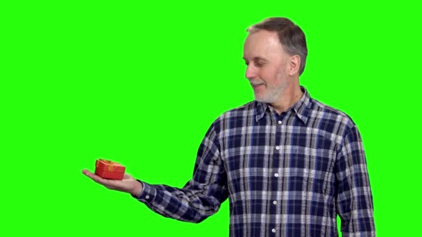 Heureux Homme Âgé Annonçant Une Boîte Cadeau Rouge Sur Main — Video