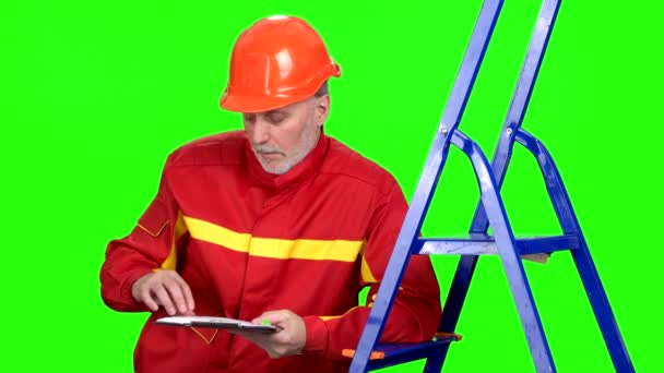 Rijpe Blanke Bouwvakker Rood Uniform Schrijft Iets Zijn Klembord Met — Stockvideo