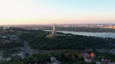 Kiev ve Dinyeper nehrindeki Anavatan anıtının insansız hava aracı görüntüsü. Arka planda şehrin ufuk çizgisi.
