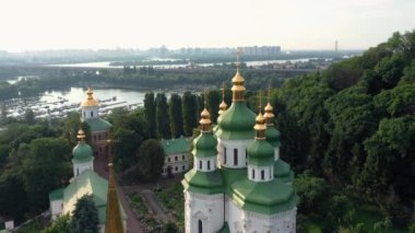 Yeşil çatılı, altın kubbeli ve arka planda Dnipro nehri olan kilise manzarası. Ukrayna 'nın Kyiv şehrinin havadan panoramik görüntüsü.