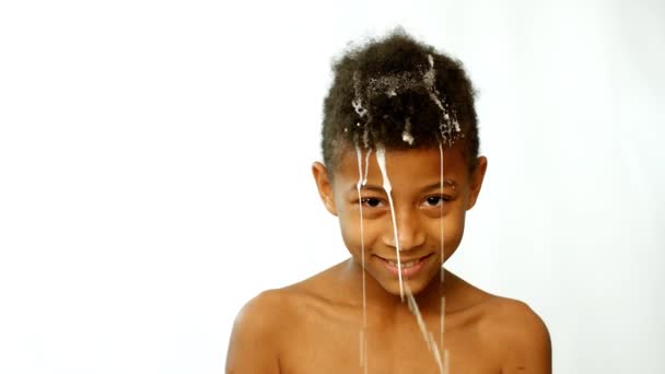 牛奶倒在一个黑皮肤的男孩身上 小男孩的演技 — 图库视频影像