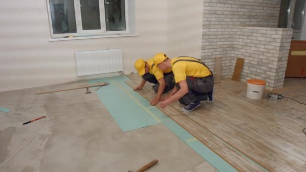 Trabalhadores Leigos Piso Laminado Uma Nova Casa Obras Reparação Interna — Vídeo de Stock