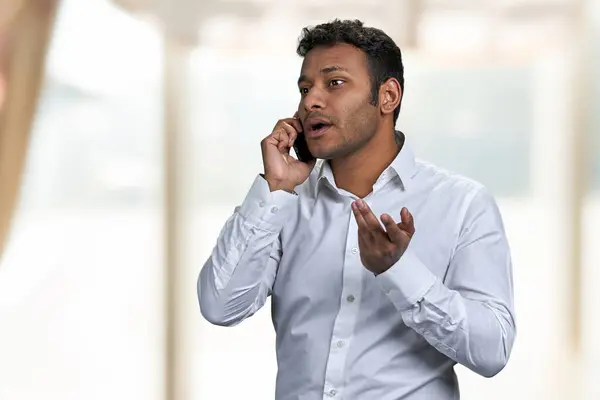 Jovem Empresário Sério Falar Com Alguém Telemóvel Blur Fundo Interior — Fotografia de Stock