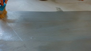İnşaatçı boyacı astar beton zemin. İşçi boyanın altındaki zemini hazırlıyor.