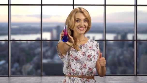 Boldog Szőke Parfümöt Használ Nyakán Felemeli Hüvelykujját Kockás Ablak Városképpel — Stock videók