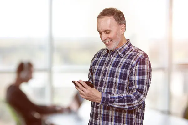 Portrait Smiling Mature Man Using Mobile Phone Office Watching Video Stock Image