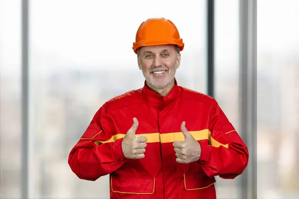 Portrait Smiling Handyman Construction Worker Showing Both Thumb Blurred Windows ロイヤリティフリーのストック写真