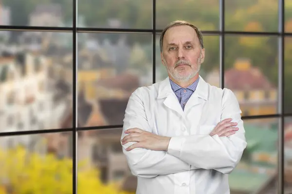 Portrait Happy Mature Male Doctor Folded Arms Checkered Windows Backgorund Stock Image