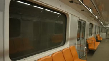 İstasyonda yeni metro treni. Yolcuları olmayan turuncu koltuklu bir metro vagonu..