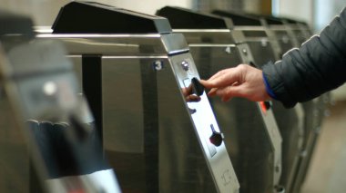 Yolcu turnikeye geçmek. İnsanlar ücret ödüyor. Yolcu giriş belirtisi atmak. Toplu taşıma. Altyapı.