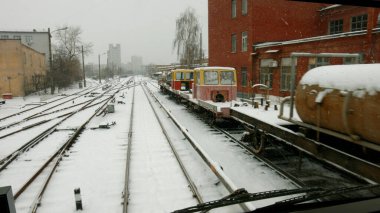 Demiryolu rayları eski bir fabrikayla sanayi bölgesinden geçiyor. Şehirdeki demiryolu deposu karla kaplıydı..
