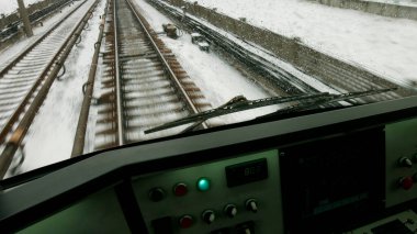 Tren raylar boyunca ilerliyor. Kontrol paneli olan tren sürücüleri kabini.