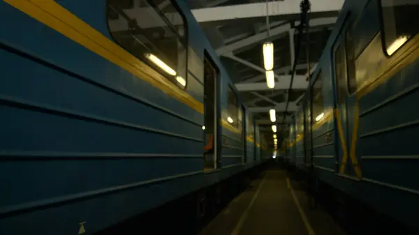 stock image A modern metro train stands in the depot. Train cars are lined up along the track, technicians are checking wheels and undercarriage.