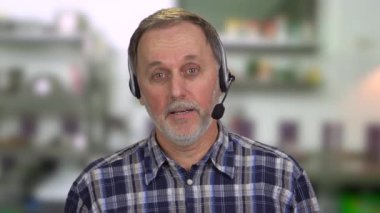 Kafkasyalı üst düzey bir müşteri destekçisinin portresi. Kulaklık takıyor ve konuşuyor. Bulanık arkaplan.