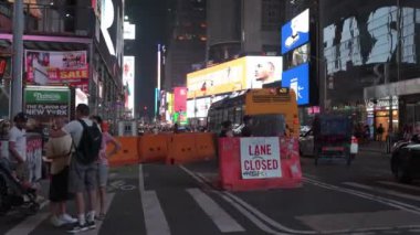 New York, USA 07.28.2024: Kalabalık Zaman Meydanı gece. Times Meydanı 'nda yoğun bir gece, inşaat şeridi kapalı, parlak reklam panoları ve yayalarla çevrili..