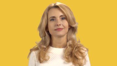 Mavi gözlü çekici sarışın bir kadının portresi. Sarıda izole edilmiş..