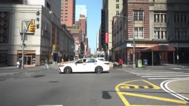 New York City, New York, ABD - 08.01.2024: Manhattan, New York 'ta trafik ve yayalarla kesişme. Sahne, güneşli bir günde yayaları, dükkanları ve yüksek binaları yakalıyor.
