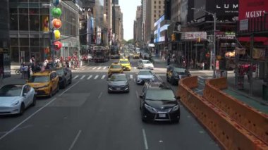 New York City, New York, ABD - 08.01.2024: Arabalar, taksiler ve otobüsler Times Meydanı sokaklarını doldurarak hareketli bir trafik sahnesi yarattı. Yayalar kaldırımlara dizilmiş, dükkanlarla çevrili.