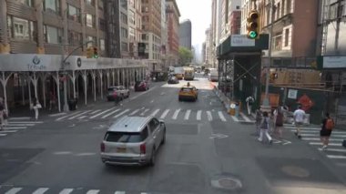 New York City, New York, ABD - 08.01.2024: Manhattan şehir merkezindeki canlı bir kavşak, caddeyi geçen yayalar ve taksiler de dahil olmak üzere araçlarla şehir hayatının hareketliliğini yakalar,