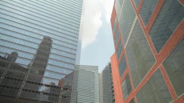 Görüntü, Manhattan şehir merkezindeki modern ofis binalarının cam pencerelerindeki çoklu gökdelenlerin yansımasını yakalıyor. Cam ve tuğla arasındaki zıtlık çarpıcı bir şehir yaratıyor.