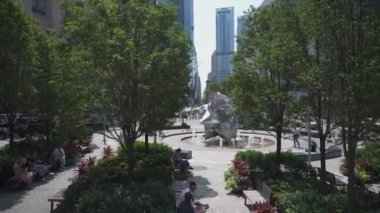 New York City, New York, ABD - 08.01.2024: Bu görüntü Manhattan 'ın Finansal Bölgesi' ndeki ikonik Oculus binası yakınlarındaki huzurlu bir şehir parkını yakalar. İnsanlar modern fıskiyenin yanında dinleniyor.